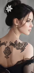 a woman with black tattoos and flowers on her back