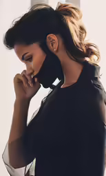 woman in black blouse looking into distance with hands to her face