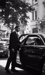 man in a suit gets his car loaded into the trunk