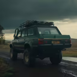 a truck parked on the side of a dirt road under dark clouds
