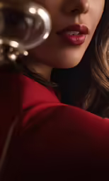 a woman wearing a red jacket holding a wine glass
