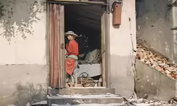 an old man wearing an orange uniform walking into the room