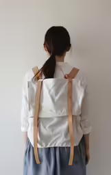 a young girl wearing suspenders and a backpack
