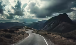 an empty road with dark clouds in the sky
