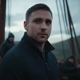 a close up of a person wearing a black jacket near a boat