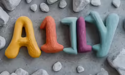 a word written in colored sand with rocks and stones