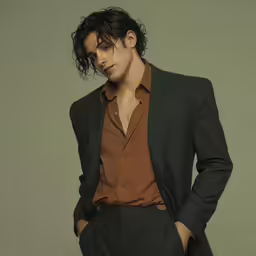 a man wearing a suit is posing for a photo