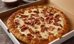 a pizza with bacon and cheese is in a box