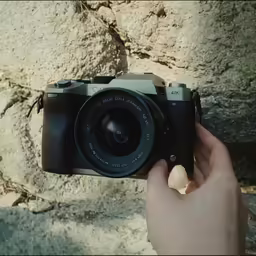 the camera is placed on the ground next to a rock wall