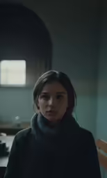 woman in a black coat standing in front of a table
