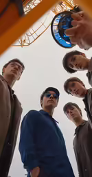 five people standing in front of an amusement coaster