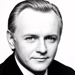 a man in suit and tie is smiling for the camera