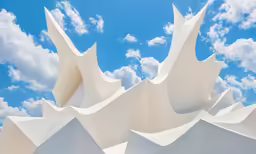 several umbrellas standing up against a blue sky