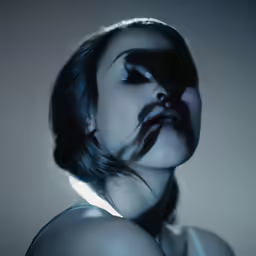 a woman with black hair and makeup with a collared top on