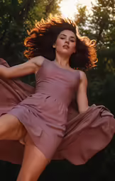 the beautiful young woman in a dress runs through the air