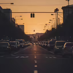 the sun is setting behind the street lights