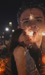 the man is kissing the girl with his hand on her forehead