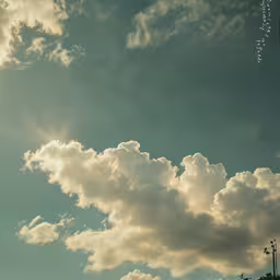 the sun is setting and bright clouds are high in the sky