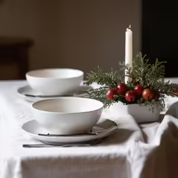 a candle is placed next to dishes and a plate
