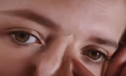the young woman is holding her face to her eyes