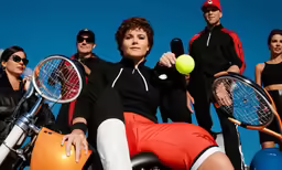 a woman holding a tennis ball while sitting on a motorcycle