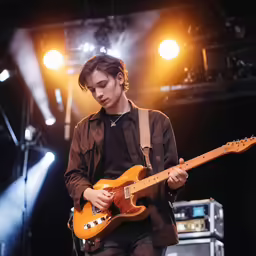 a man holding a guitar with his right hand