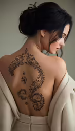 a woman with a tattoo on her back and behind