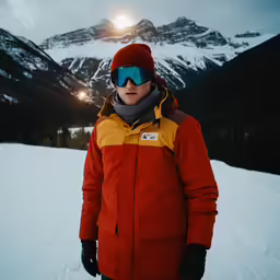 a man in snowsuit and sunglasses on skis standing in the snow
