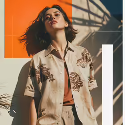 woman leaning on orange wall in beige shirt and jeans
