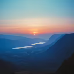 a beautiful sunset with the sun rising over the mountains