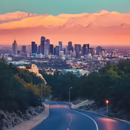 a street and road leading to a city with mountains in the background