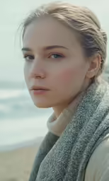 the woman is wearing a gray sweater and scarf