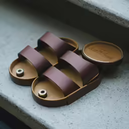 a pair of leather slippers laying on some stairs