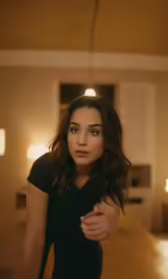 a woman with long hair in black shirt near light