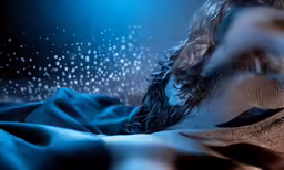 a person covered in a blanket in the dark