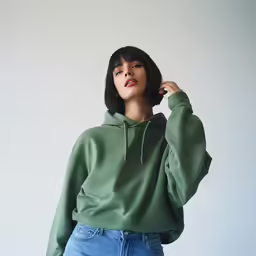 a woman in a green hoodie standing and looking away