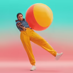 woman wearing blue jean and orange pants holding an inflatable ball