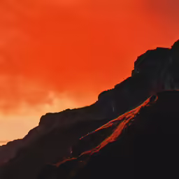 there is a orange sky over the mountains