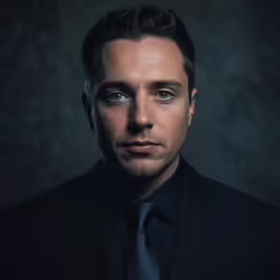 a man with a tie looking forward at the camera