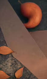 an orange and a piece of cardboard on the ground