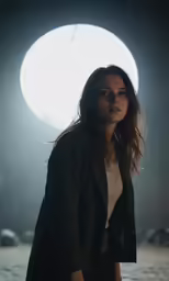 the beautiful woman is posing in front of a round light