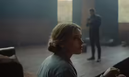 a woman standing next to a man holding something