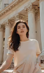 a woman stands in front of a building with columns