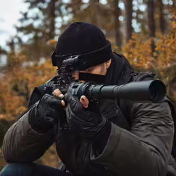 a man in a black hat is shooting