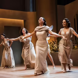 four women are performing on a stage with one dancer dancing
