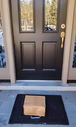 a brown paper bag sitting on the front door of a house