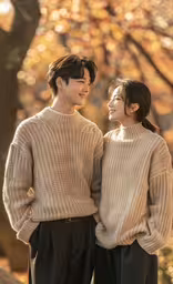 a young asian couple standing next to each other,an asian couple who is looking at each other, in the autumn