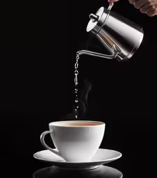 a steaming coffee being served into a cup