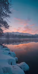 the sun sets over the water at a lake