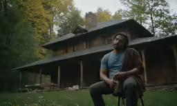a man sitting in a chair outside a house